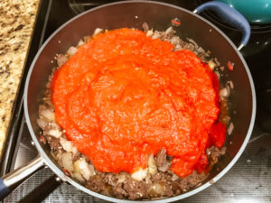 Sauce poured over browned ground beef.