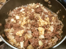 Ground beef, onion, and garlic in sauce pan.
