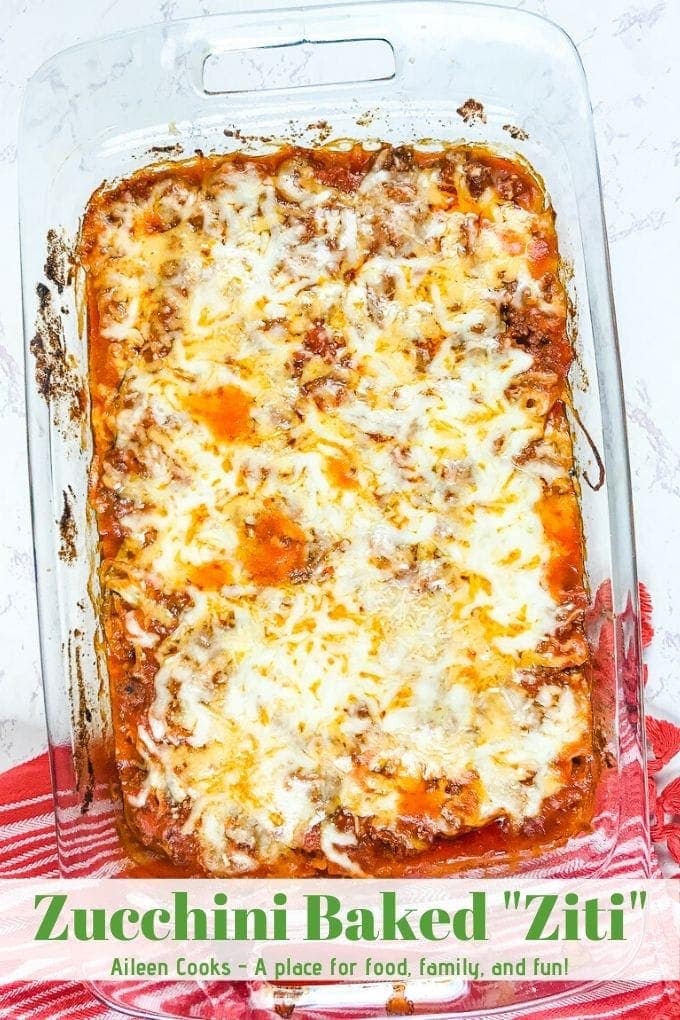 A glass casserole dish filled with zucchini baked ziti with cheese melted on top.