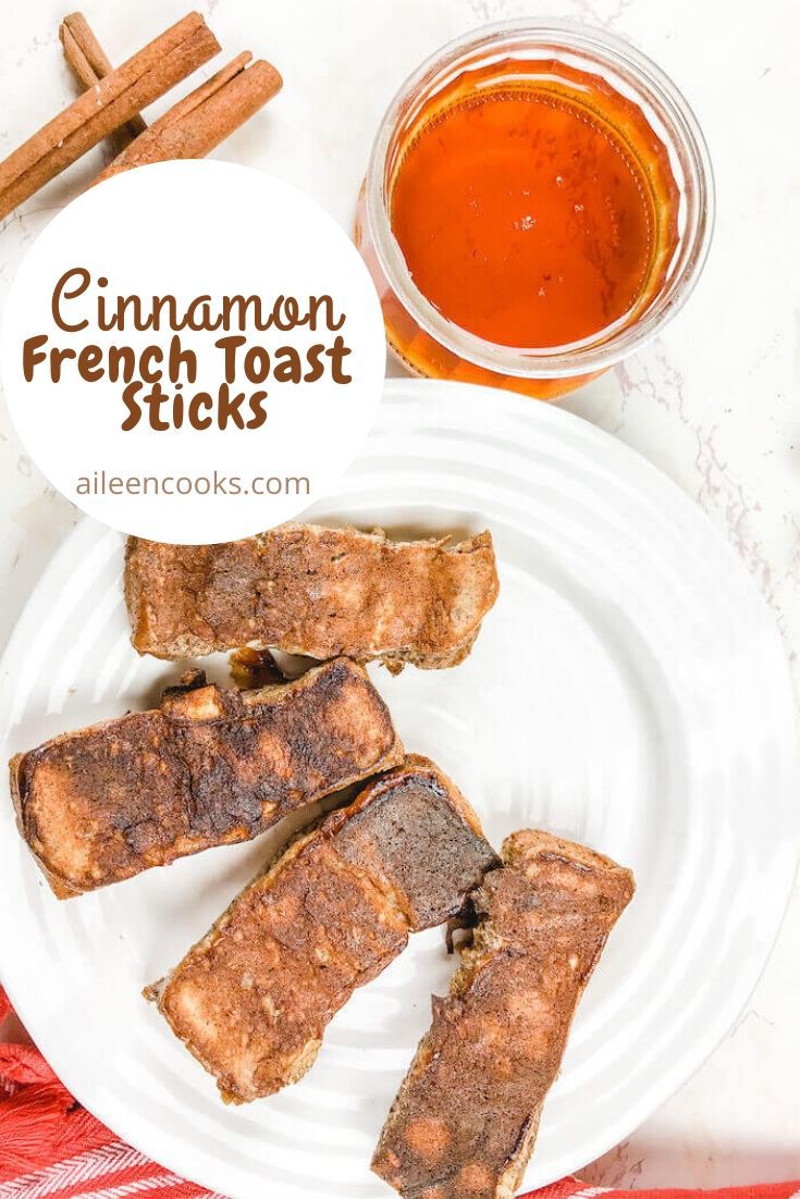 A plate of four French toast sticks with the words "cinnamon French toast sticks" in brown writing.