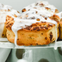 Close up of cinnamon rolls on a cake stand.
