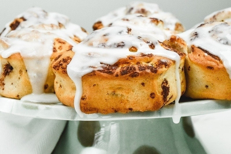Close up of cinnamon rolls on a cake stand.