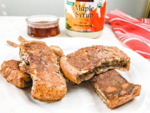 Close up of French toast sticks on a white plate.