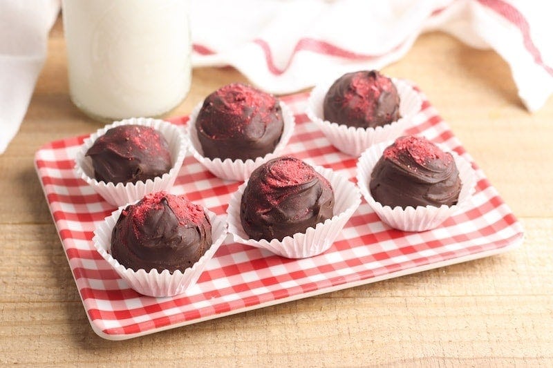 A red checkered platter filled with dark chocolate truffles.