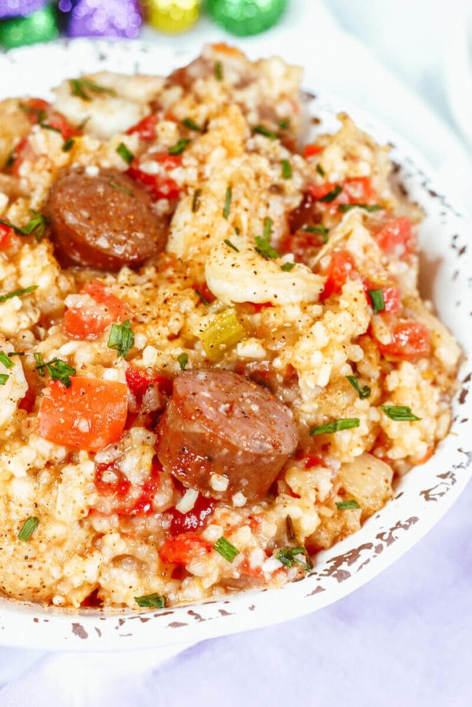 A close up of jambalaya with sausage and shrimp in a white bowl.