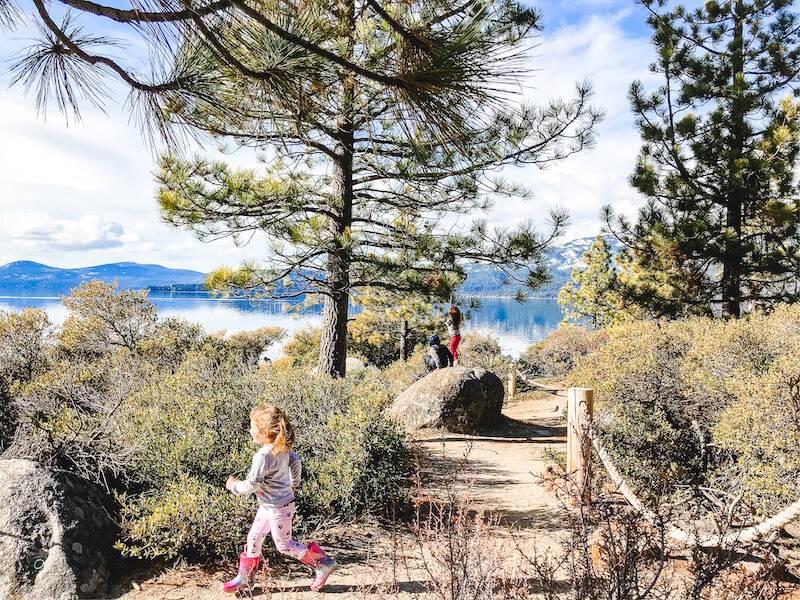 A little girl running along the trail next to Lake Tahoe.