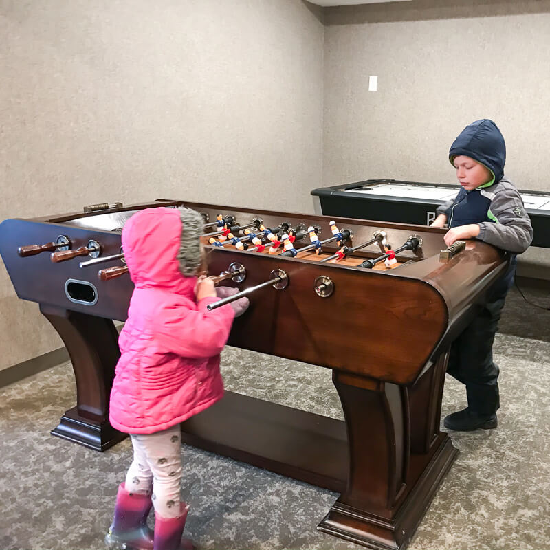 Two small kids playing inside the game room at Hotel Azure.