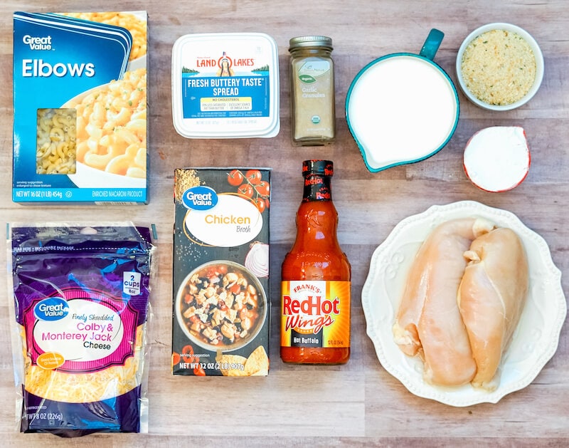 All off the ingredients for buffalo Mac and cheese laid out on a wooden countertop.