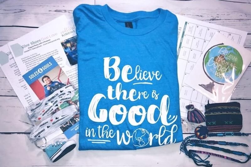 A blue shirt that says "believe there is good in the world"