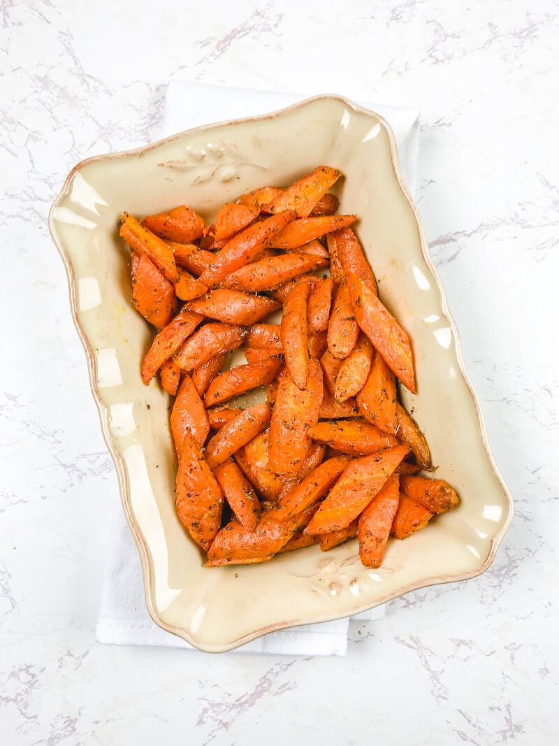 A beige serving dish filled with air fried carrots.