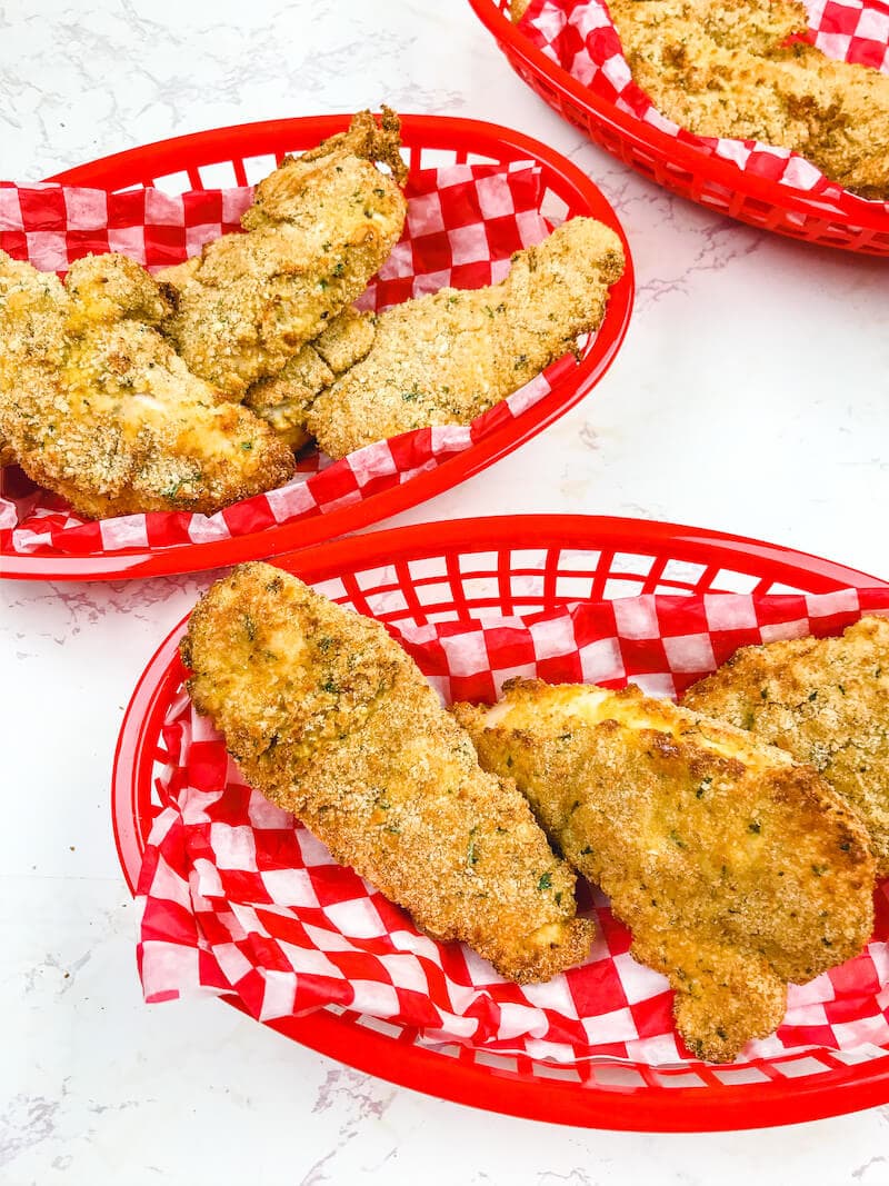 Three baskets full of crispy air fryer chicken tenders.