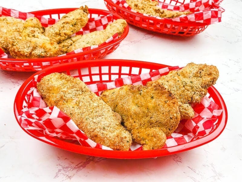 A red basket of crispy chicken tenders.