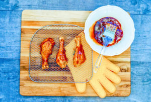 An air fryer tray coated with bbq sauce.