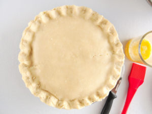 Chicken pot pie prepared with second crust on top and edges of crust crimped.