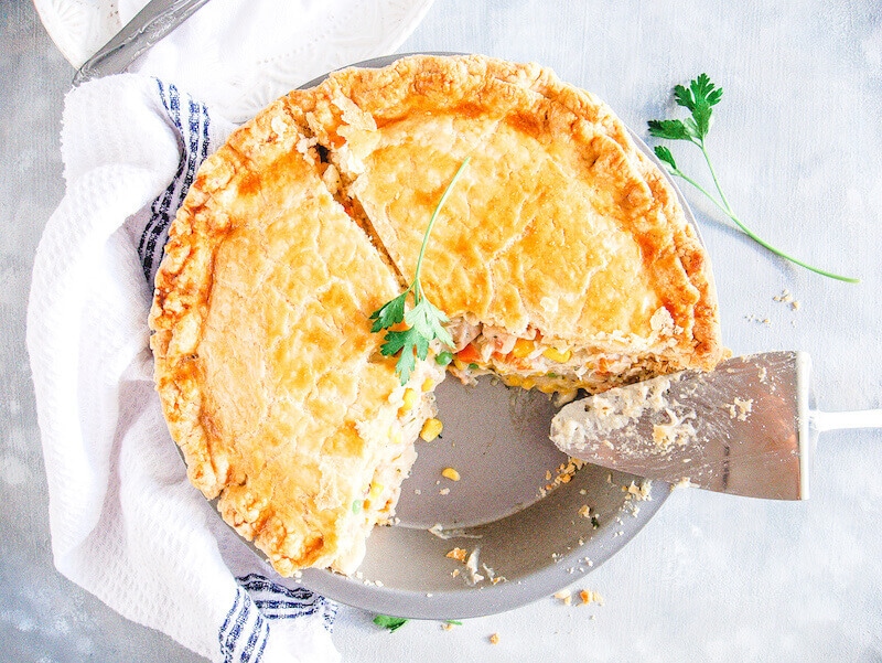 A chicken pot pie with two slices cut out of it.