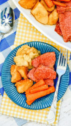 Close up of corned beef and cabbage on a blue plate.