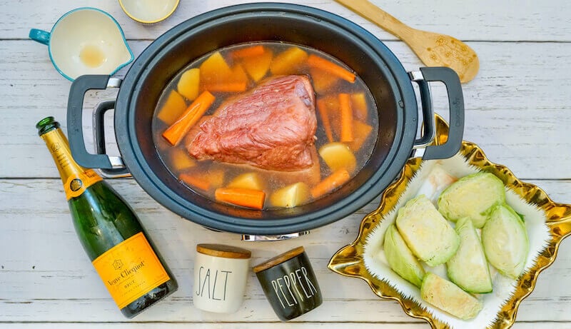 Brisket, carrots, and potatoes inside crock pot.