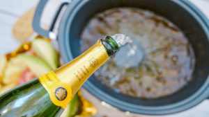 Champagne being poured into crock pot.