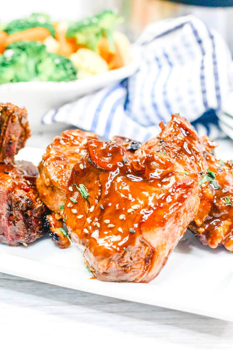 Close up of lamb chops with sesame seeds and chives.