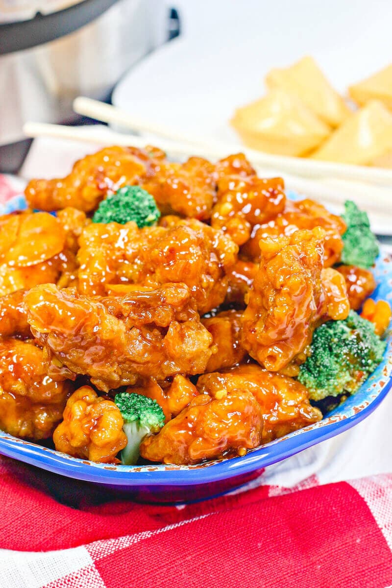 Close up of orange chicken in a blue bowl.