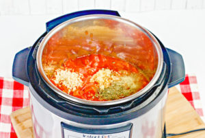 Instant pot filled with spicy spaghetti ingredients.