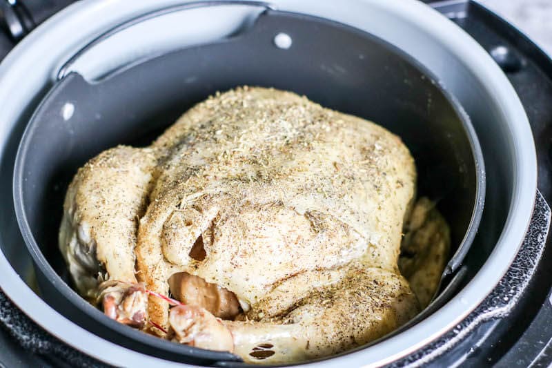 Whole pressure cooked chicken sprinkled with herbs.