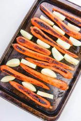 Carrots and apples on a cookie sheet.