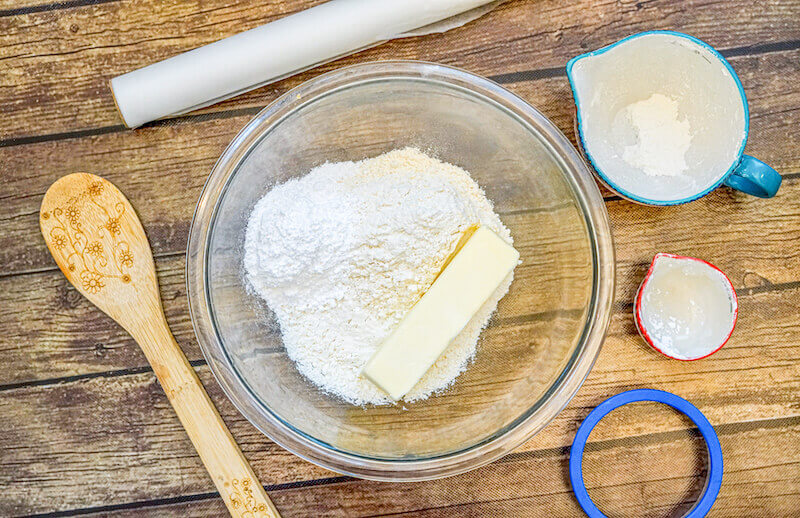 Butter, sugar, and flour combined in a glass mixing bowl.