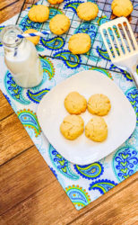 Overhead shot of a plate of cookies next to a cooling rack full of 3 ingredient shortbread cookies.