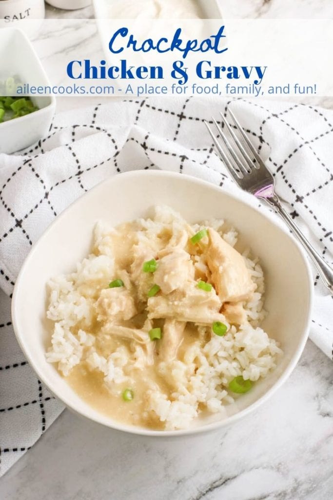 A white bowl of rice topped with chicken and gravy with the words "crockpot chicken & gravy" in blue letters.