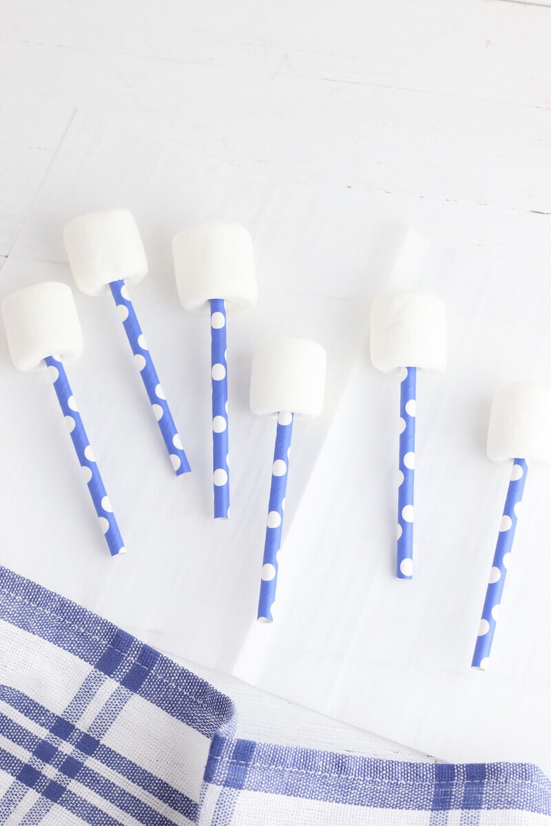 Plain marshmallows with blue and white striped paper straws stuck out of the bottom.