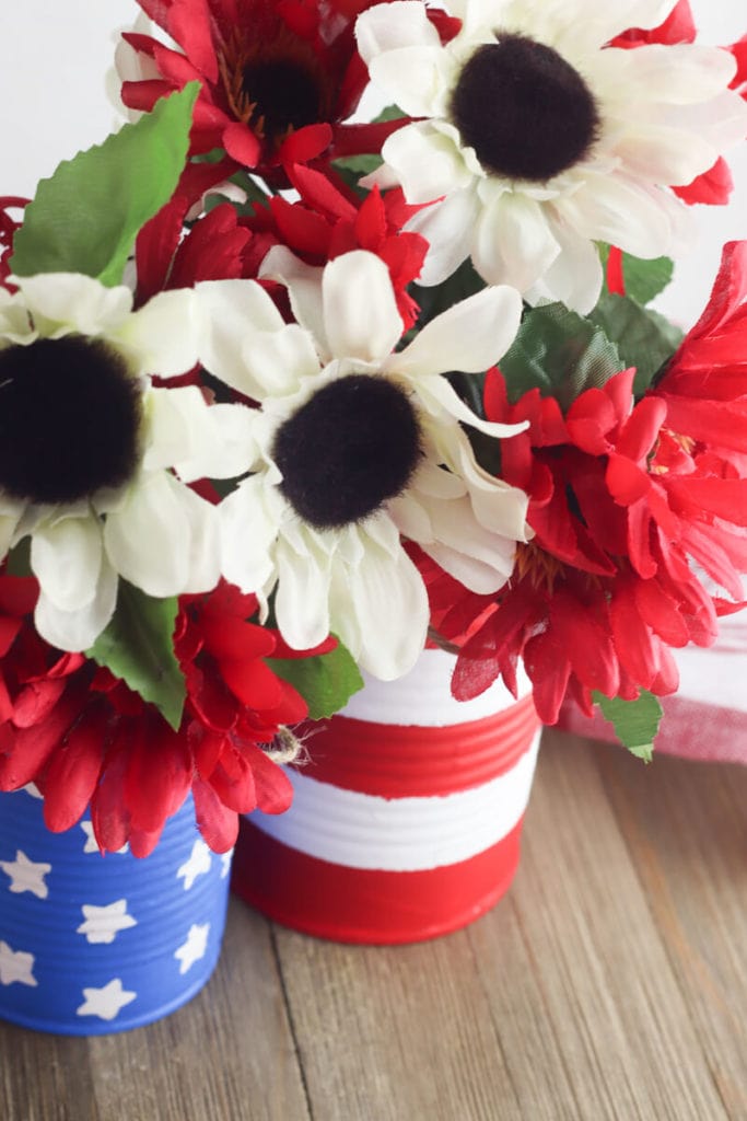 Close up of white flowers inside american flag painted vases.