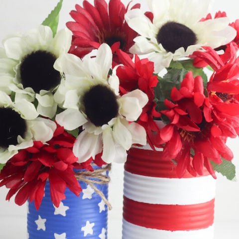 Two vases made of tin cans and painted to look like the American Flag.