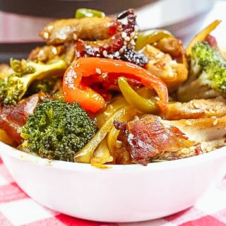 Close up of honey garlic chicken topped with broccoli and bell peppers.