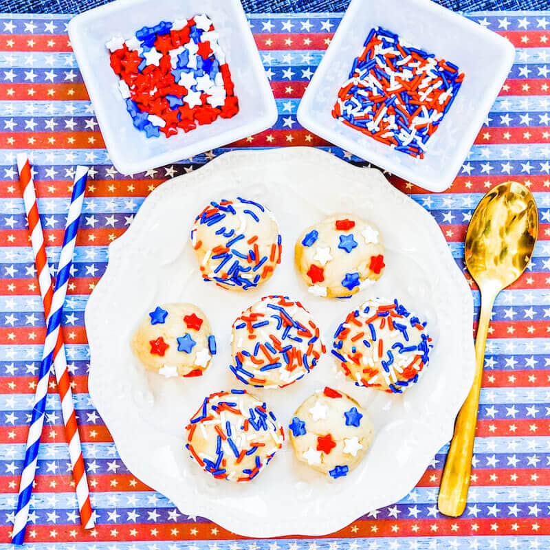 A plate filled with edible cookie dough topped with stars and stripes sprinkles.