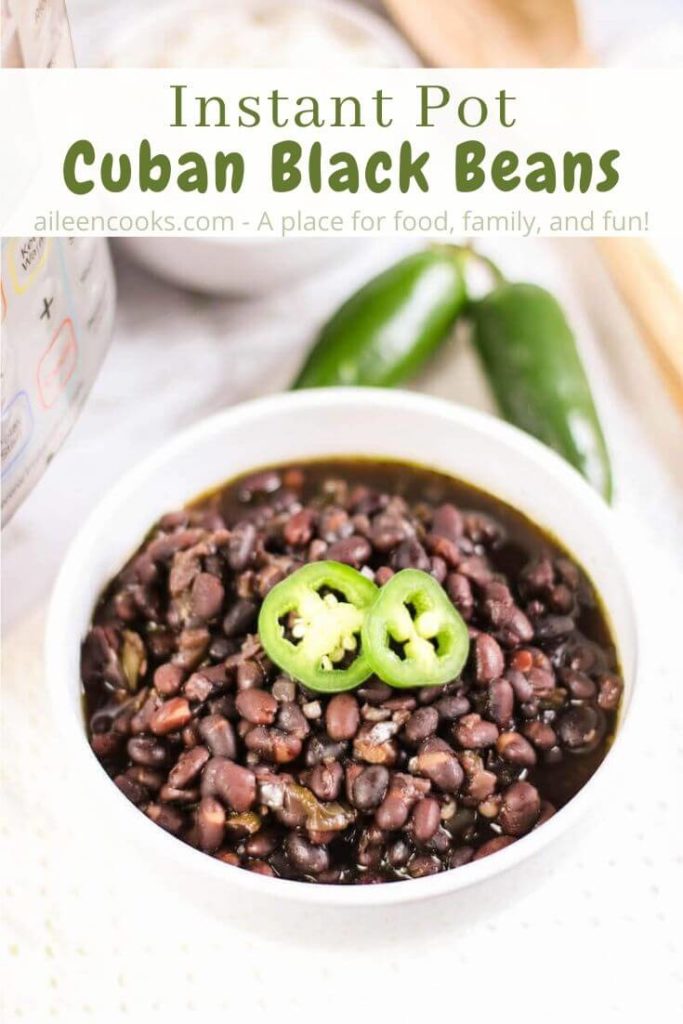 A white bowl of cuban black beans in front of an instant pot with the words "instant pot cuban black beans" in green lettering.