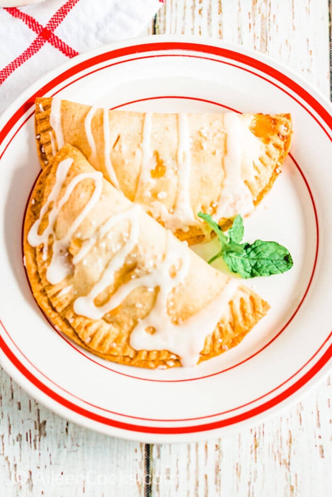 A white and red plate with two hand pies on it.