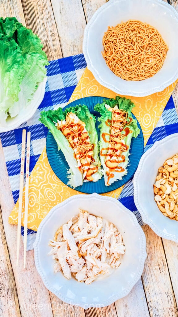 A plate of asian chicken lettuce wraps next to a pair of chopsticks.