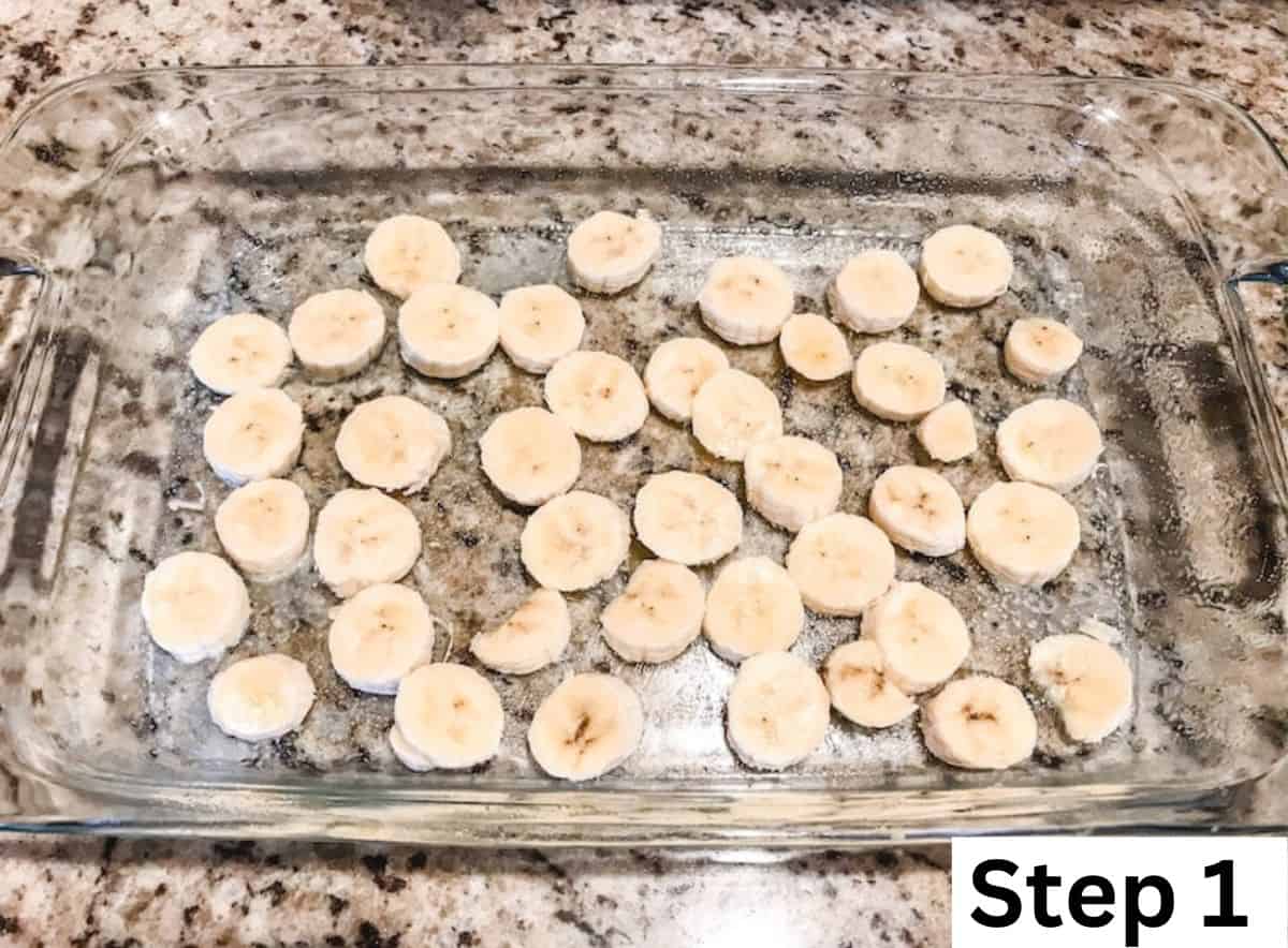 Sliced bananas arranged in the bottom of a glass baking dish.