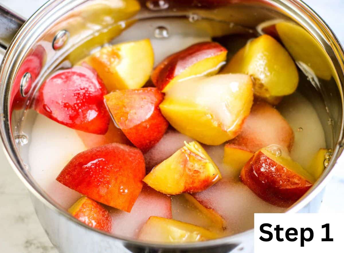 Chopped peaches, sugar, and water inside a stock pot.