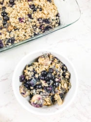 Overhead shot of a white bowl filled with blueberry baked oatmeal.