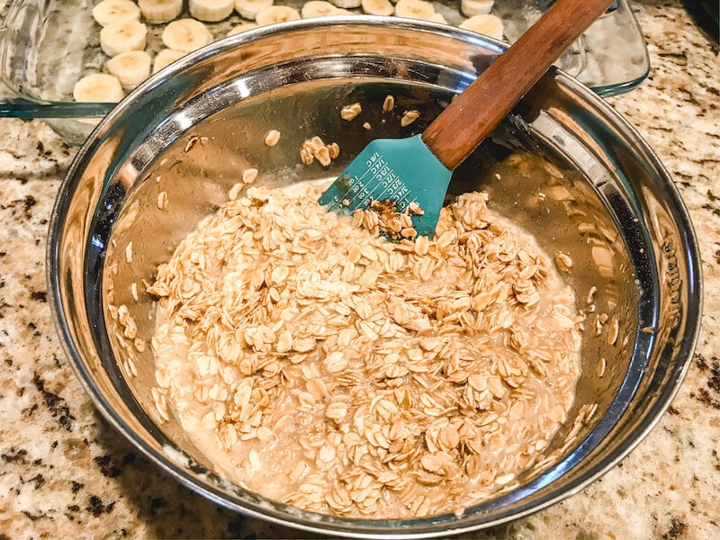 A metal mixing bowl filled with baked oatmeal ingredients. 
