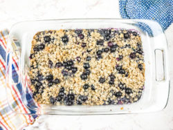 A glass baking dish filled with baked oatmeal and topped with blueberries.