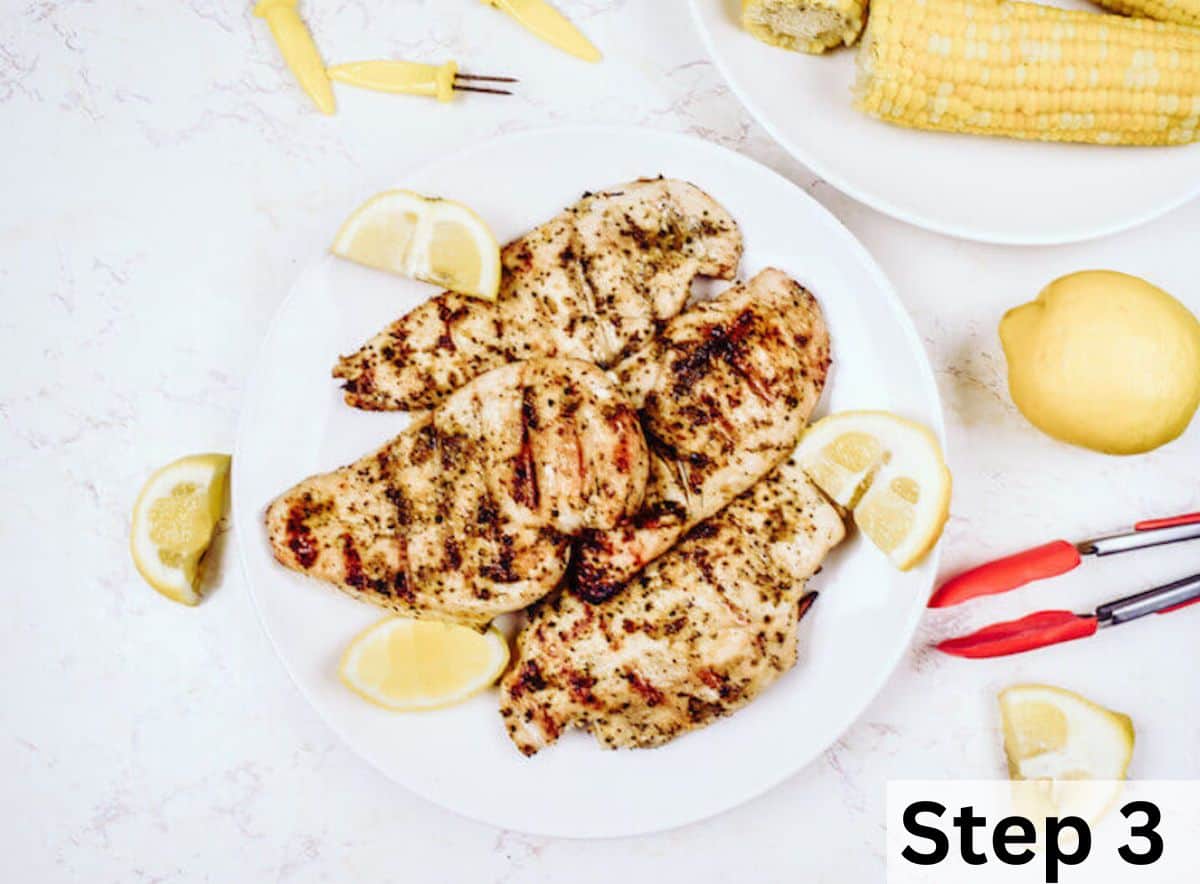 A plate full of grilled chicken and lemon slices.