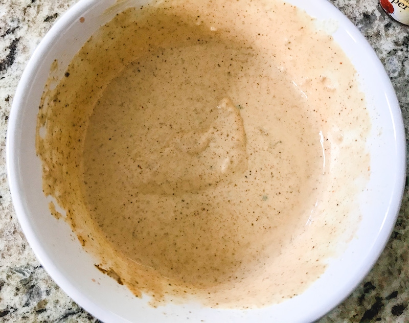 A white bowl filled with homemade remoulade sauce.