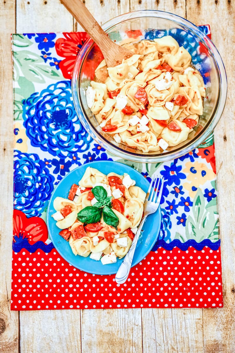 Pasta salad on a red and blue colorful placemat.