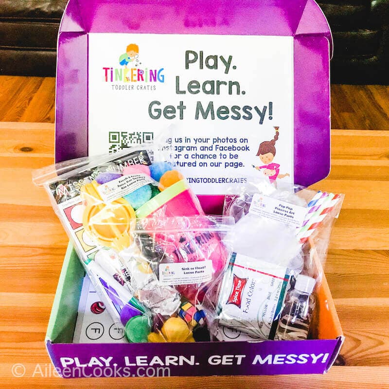 A purple box that says play, learn, get messy.