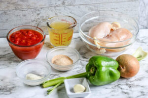 Ingredients for chicken creole on a marble countertop.
