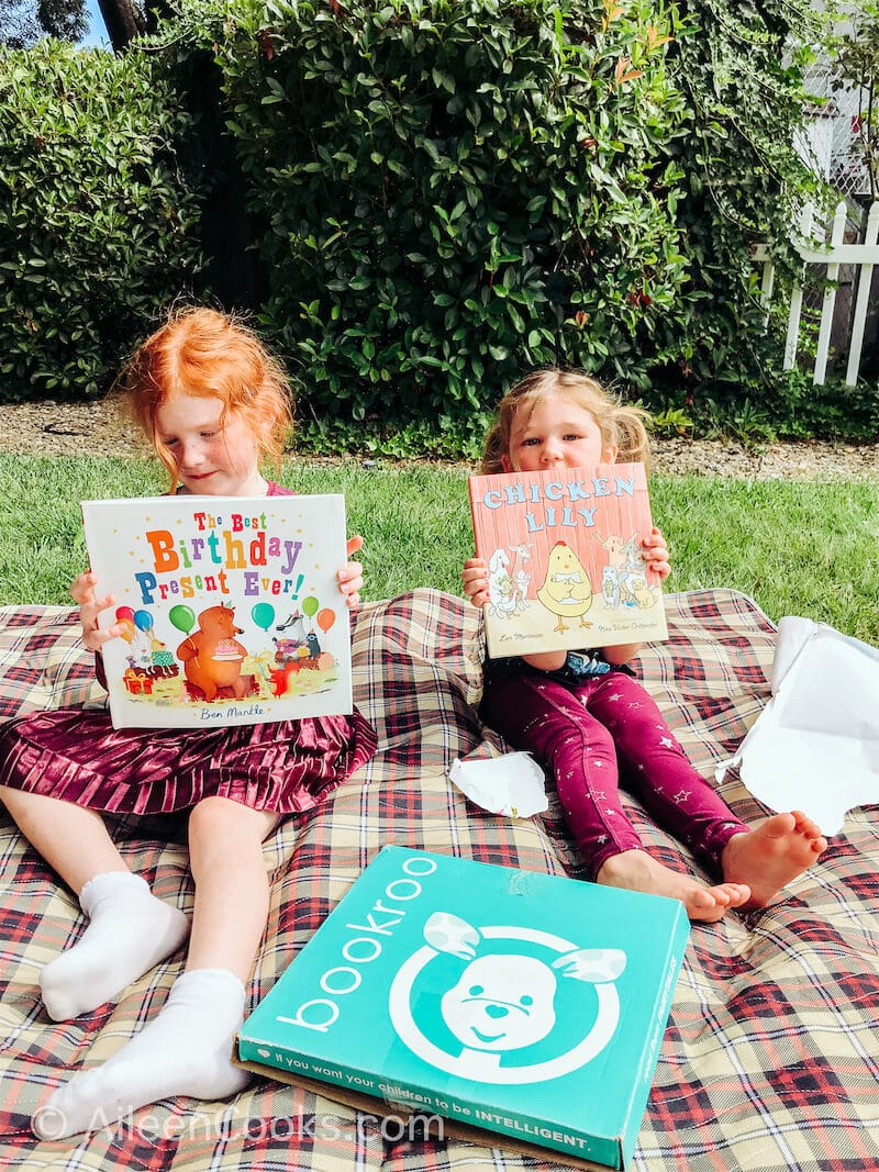 Two girls holding up new picture books.