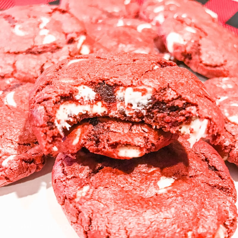 Close up of red velvet white chocolate chip cookie with a bite taken out of it.